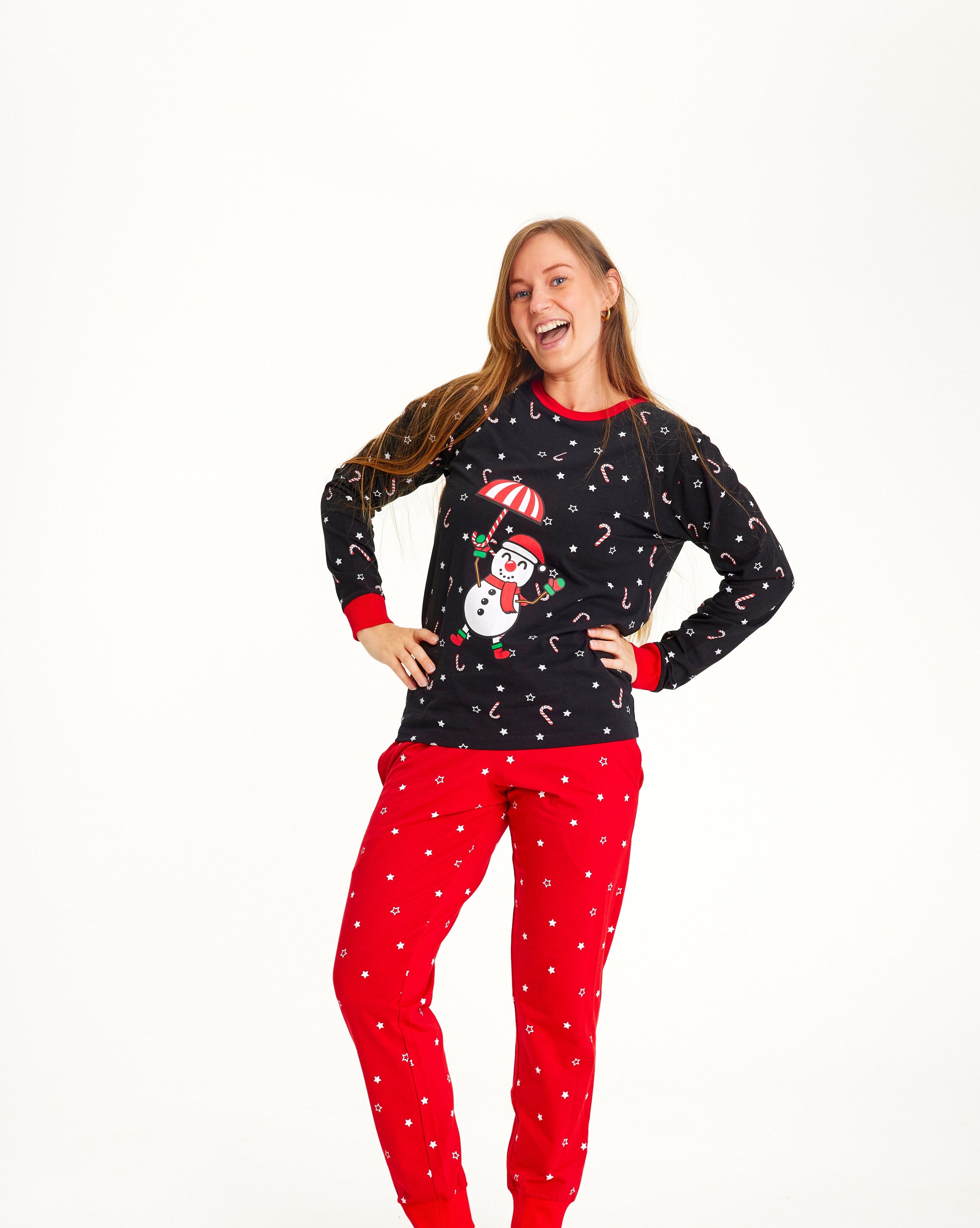En kvinne har på seg en svart og rød julepyjamas med snømann på.